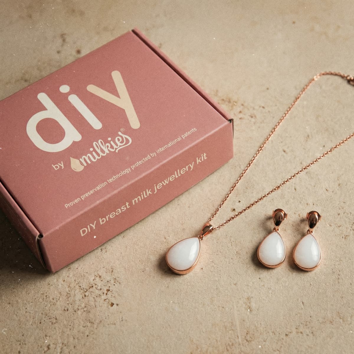 Coffret DIY by MILKIES pour créer un bijou souvenir en lait maternel, idée de cadeau femme enceinte, avec pendentif et boucles d’oreilles goutte en métal rose doré.