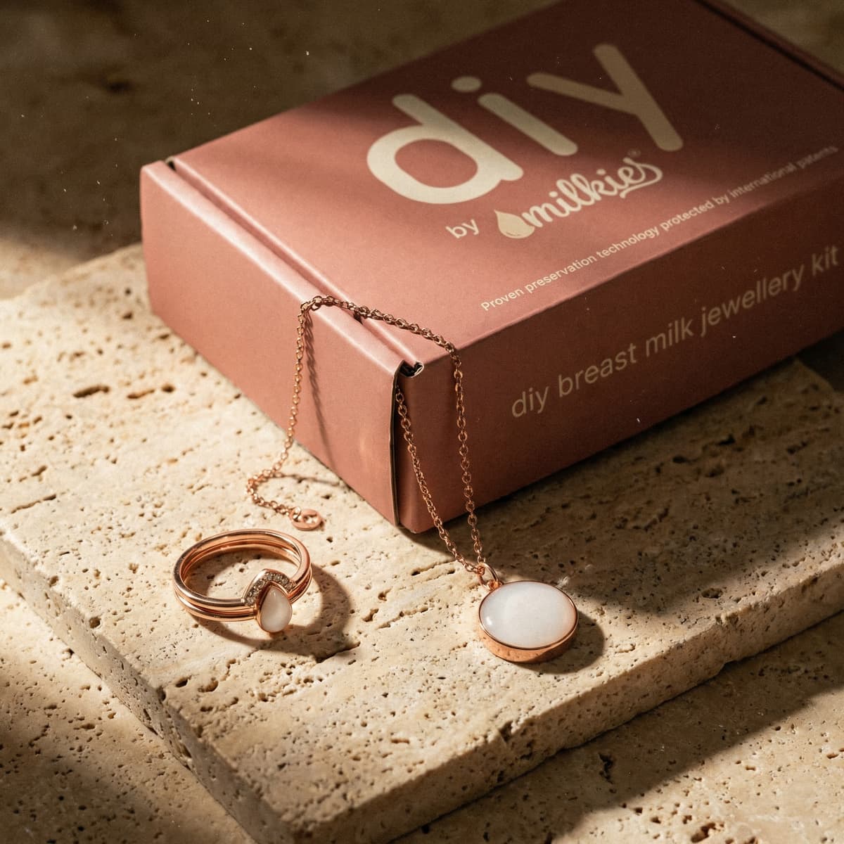 Boîte DIY by MILKIES présentant un kit moulage lait maternel avec bijoux rose gold (collier et bague) en résine blanche pour créer un souvenir personnalisé à la maison